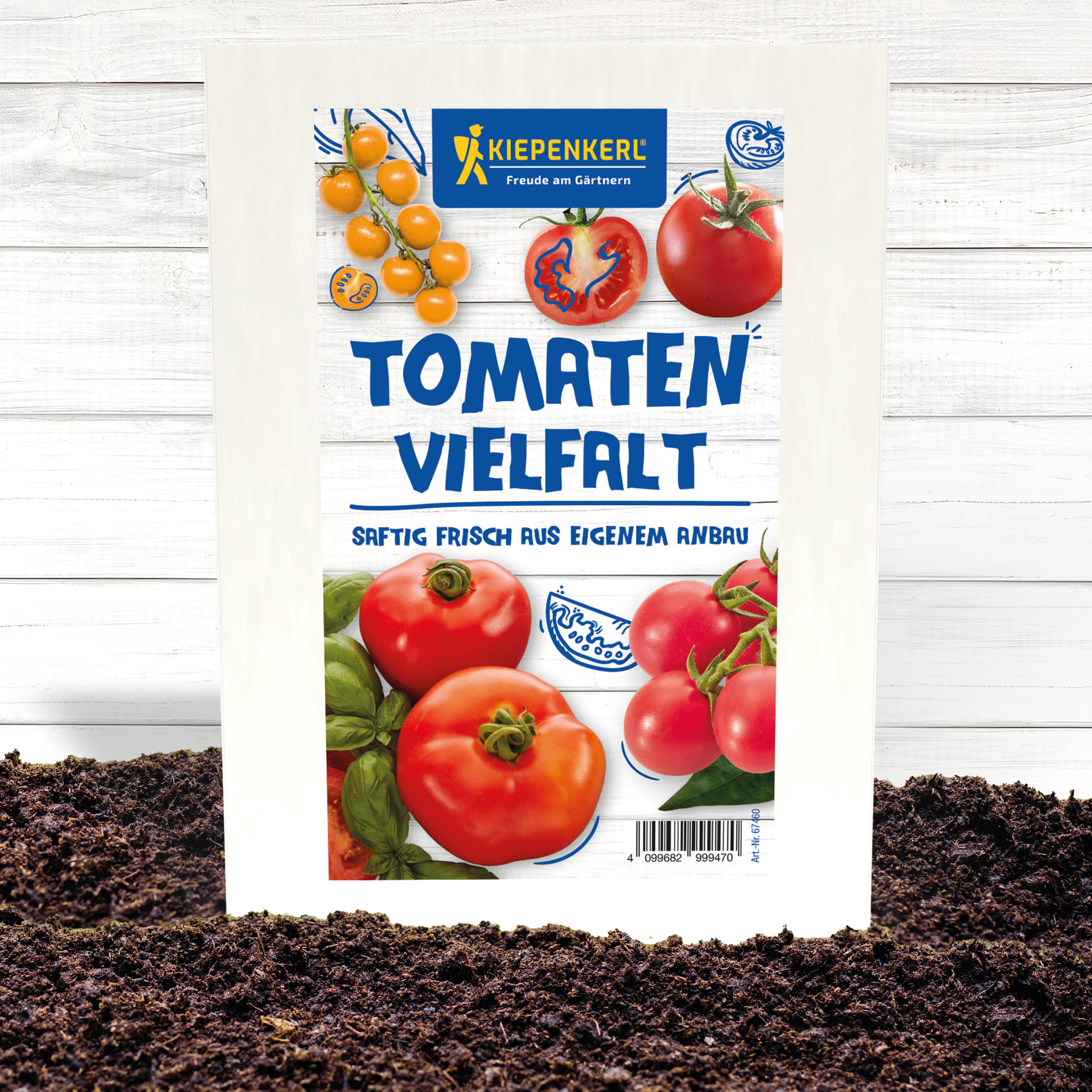 Pappkarton mit Tomatensamen, auf Erde vor weißem Holz, mit Tomatenbildern und Kiepenkerl Logo.