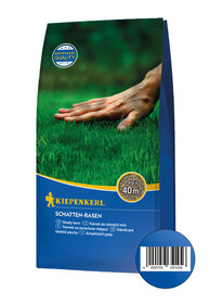 Hand berührt grüne Rasenfläche auf Verpackung, Kiepenkerl Schattensamen, 1 kg für 40 m², Barcode am unteren Rand.
