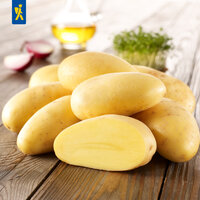 Mehrere Kartoffeln auf einem Holzbrett, im Hintergrund Knoblauch, Öl und Kräuter.