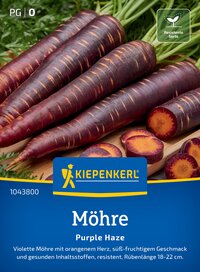 Violette Möhren mit orangefarbenem Herzen, auf Holzbrett, daneben Scheiben, grüne Blätter im Hintergrund.