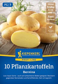 Zwei geschälte und mehrere ungeschälte Kartoffeln auf einem Holzbrett, im Hintergrund Gewächs.