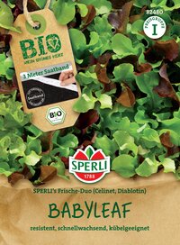 Grüner Blattsalat aus der Packung mit braunem Papierhintergrund und Label mit "Babyleaf" Text