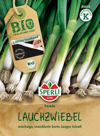 Lauchzwiebeln mit grünen Stangen und weißen Enden auf Holztisch, Verpackung mit Etikett, Logo und Text.