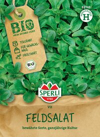 Feldsalat mit grünen Blättern auf Saatgutverpackung, Markennamen Sperli und Bio, grüner Hintergrund.