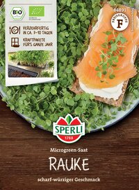Mikrogreen Saat Rauke, auf Holzplatte mit grünen Keimlingen und einem belegten Brötchen mit Räucherfisch, Frischkäse und Kresse.
