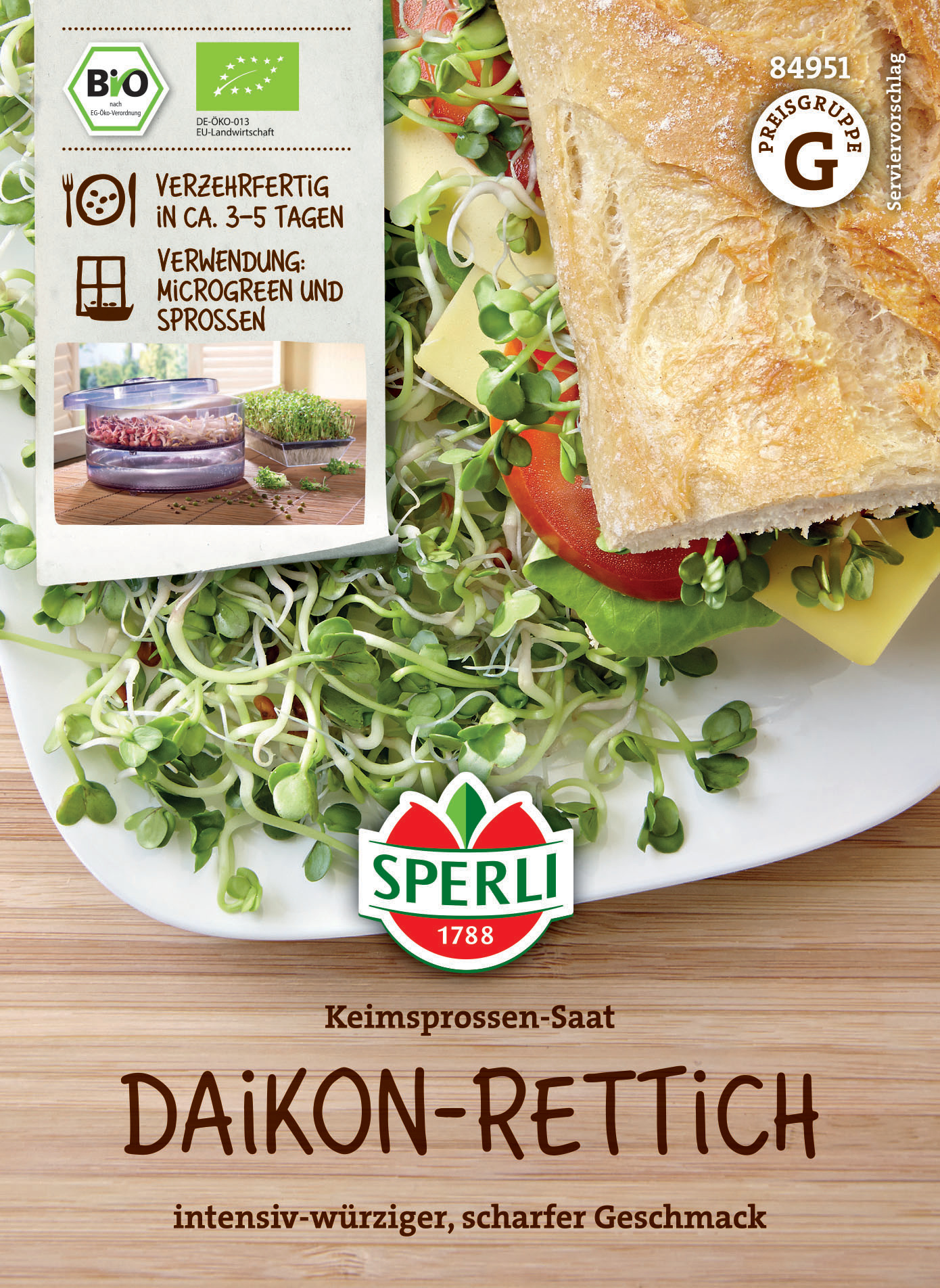 Keimsprossen-Saat auf einem Teller mit Brot, Tomate, Käse und Salat, Verpackung in der Ecke sichtbar.